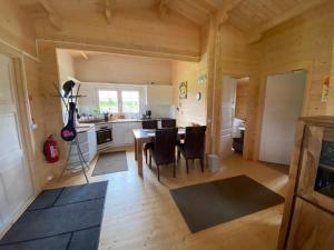 a kitchen and dining room with a table and chairs at Ferienhaus an der Ostsee in Vaisi