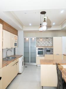 a kitchen with white cabinets and a washer and dryer at Family Comfort Suites in Rawalpindi