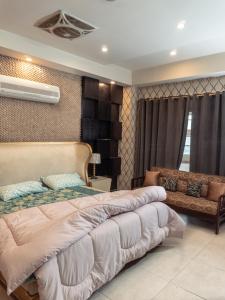 a bedroom with a large bed and a couch at Family Comfort Suites in Rawalpindi