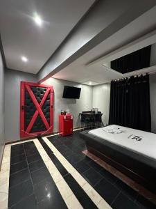 a bedroom with a bed and a red door at Motel Vitoria Reggia in São Vicente