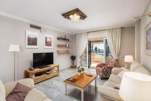 ein Wohnzimmer mit Sofa und Fernseher in der Unterkunft Lemon Playa in Málaga