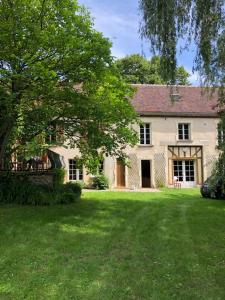 a large white house with a large yard at Maison familiale dans le Perche in Chêne