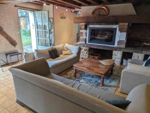 a living room with couches and a fireplace at Maison familiale dans le Perche in Chêne