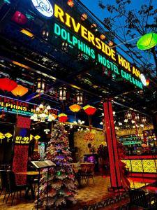 a christmas tree in front of a restaurant at night at Riverside Hoi An, Dolphins Hostel in Hoi An