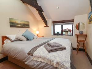 a bedroom with a bed with towels on it at Badgers Sett in Bude