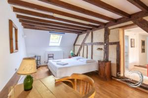 a bedroom with a bed in a room with wooden ceilings at Maison familiale dans le Perche in Chêne