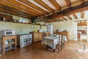 a kitchen with a table and a stove at Maison familiale dans le Perche in Chêne