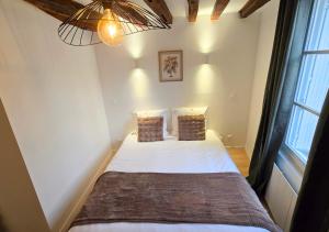 a small bedroom with a bed with white sheets and pillows at L'Immersion Tourangelle in Tours