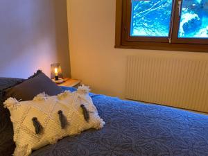 a bedroom with a bed with a pillow and a window at Résidence Maya, La Charmille in Troistorrents