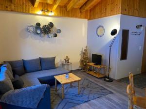 a living room with a blue couch and a table at Résidence Maya, La Charmille in Troistorrents