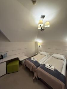 a room with two beds and a table and lights at Hotel Karpik Zator Graboszyce in Graboszyce +28 photos