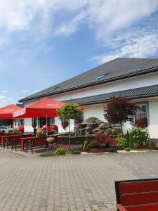 a restaurant with benches in front of a building at Hotel Karpik Zator Graboszyce in Graboszyce