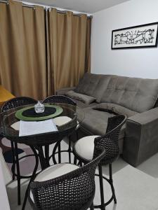 un salon avec un canapé, des tables et des chaises dans l'établissement IMPERDÍVEL APARTAMENTO em frente ao BURITI SHOPPING, à Aparecida de Goiânia