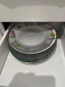 une pile de plaques assises à l'intérieur d'un micro-ondes dans l'établissement IMPERDÍVEL APARTAMENTO em frente ao BURITI SHOPPING, à Aparecida de Goiânia