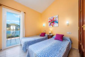 two beds in a room with a balcony at Llac D'alcudia in Port d'Alcudia +29 photos
