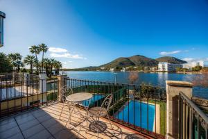 a balcony with a table and a view of the water at Llac D'alcudia in Port d'Alcudia