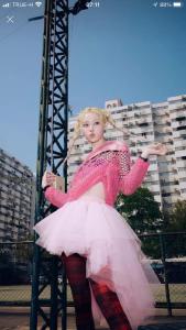 a woman in a pink dress standing on a pole at Impact Arena Condo The Classic by GoodRoom24 in Ban Song Hong