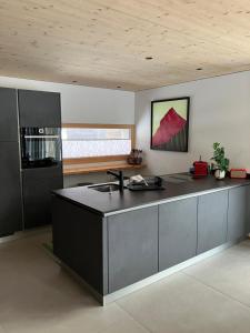 a kitchen with a black island in a room at Ca' dal Nos in Olivone