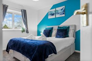 a bedroom with a large bed with blue walls at Stylish 3 Bed House, Sleeps 6, Near NEC - Airport, Parking, Contractors - Families Stay in Sheldon