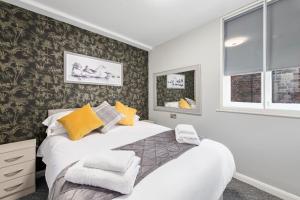 a bedroom with a large bed with yellow pillows at Still House in Boston