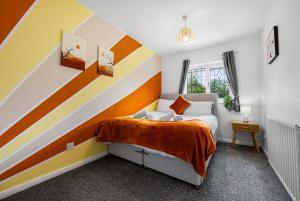 1 dormitorio con cama a rayas en la pared en Trendy 3 Bed House, Sleeps 6, Near NEC - Airport, Parking, Contractors - Families Stay, en Sheldon