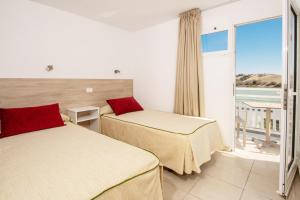 En eller flere senge i et værelse på Apartamentos Cocoteros