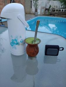 un mortaio e un pestello su un tavolo accanto a una piscina di Righi House - Casa completa com piscina e 4 quartos amplos a São Gabriel