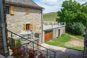 una vista esterna di una casa in pietra con balcone di Gites de france 3 epis 5 personnes a mativet a Montbrun