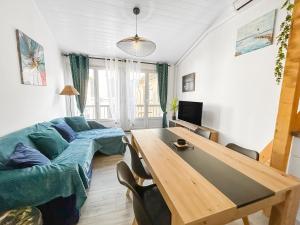 a living room with a couch and a table at Maison charmante clim et balcon en centre ville in Marseillan