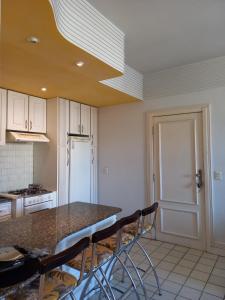 eine Küche mit einer Theke mit Stühlen und einem Kühlschrank in der Unterkunft apartamento em aréa nobre in Vitória da Conquista + 8 Fotos