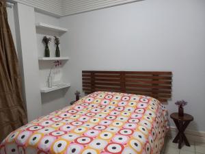 ein Schlafzimmer mit einem Bett mit einer bunten Bettdecke in der Unterkunft apartamento em aréa nobre in Vitória da Conquista