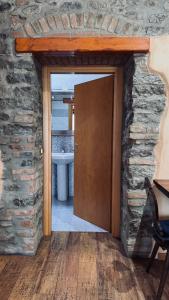 a bathroom with a door in a stone wall at B&B Al Vecchio Molino in Valbrembo