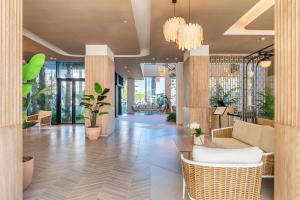 un vestíbulo con sillas y plantas en un edificio en Port Alicante City & Beach, en Alicante