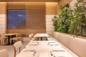 a restaurant with tables and chairs and plants at Port Alicante City & Beach in Alicante