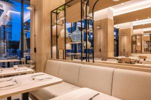 a restaurant with tables and chairs and a large mirror at Port Alicante City & Beach in Alicante
