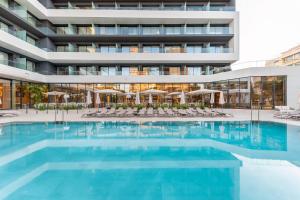 a swimming pool in front of a building at Port Alicante City & Beach in Alicante