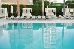 a group of chairs sitting next to a swimming pool at Port Alicante City & Beach in Alicante
