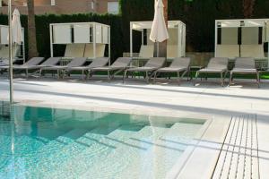 a group of chairs sitting next to a swimming pool at Port Alicante City & Beach in Alicante
