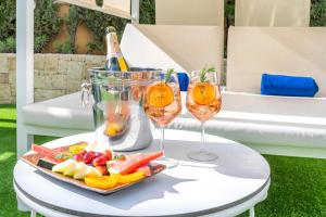 a table with two wine glasses and a tray of fruit at Port Alicante City & Beach in Alicante