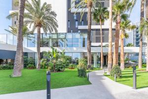 a courtyard with palm trees and a building at Port Alicante City & Beach in Alicante