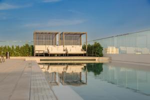 a pool of water with a couch sitting next to a building at Port Alicante City & Beach in Alicante