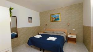 Hotel Residence Villa Ascoli في فييستي: غرفة نوم بسرير ازرق ومرآة