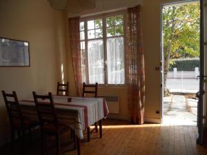a dining room with a table and chairs and a window at Villa proche centre et plage - V04245 in Soulac-sur-Mer +10 photos