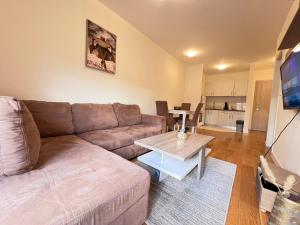 een woonkamer met een bank en een tafel bij Central Point • Apartment 59 in Podgorica +4 foto's