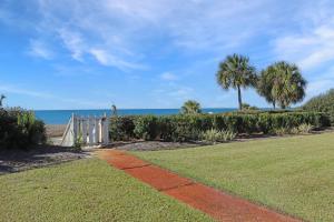 una pasarela con palmeras y el océano en el fondo en Deja Blue by Pristine Properties Vacation Rentals, en Mexico Beach