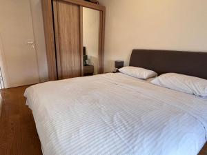 een slaapkamer met een groot wit bed met twee kussens bij Central Point • Apartment 59 in Podgorica