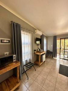 a living room with a table and a window at Ndalo Lodge Mbombela in Nelspruit