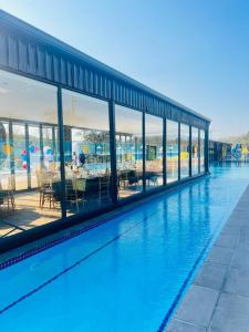 a building with a swimming pool with glass windows at Ndalo Lodge Mbombela in Nelspruit