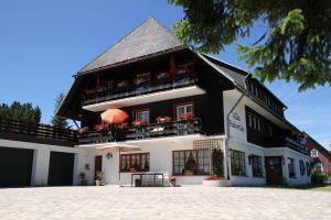a black and white building with an umbrella in front at Schwarzwald Residenz - Villa Hubertus in Feldberg