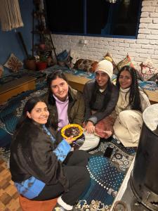 a group of women sitting on the floor with a plate of food at Kasolview Homestay and Peace Inn Cafe in Kasol +67 photos